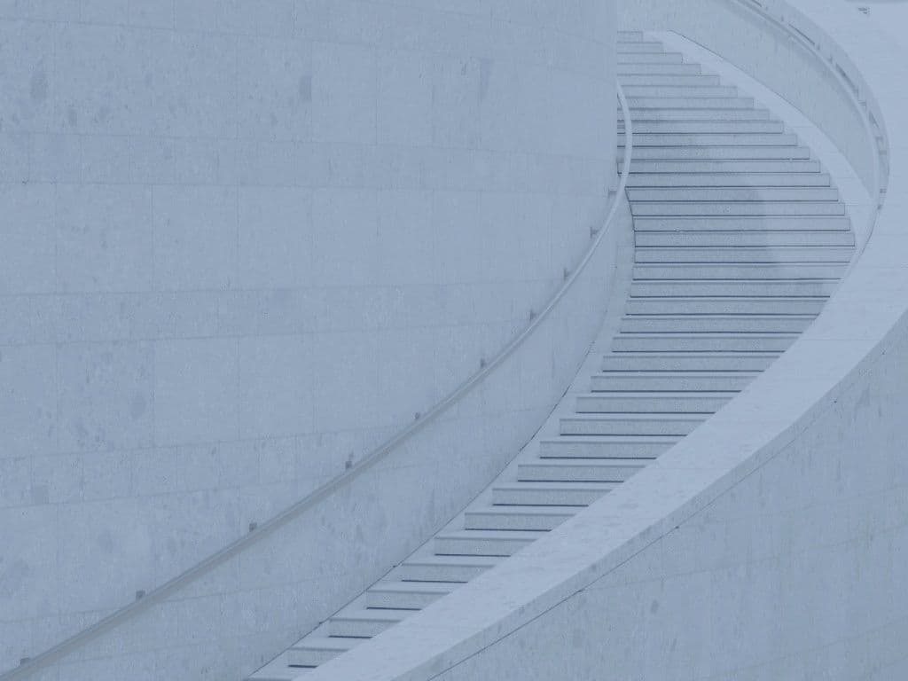 Curved stone staircase ascending, blue-toned