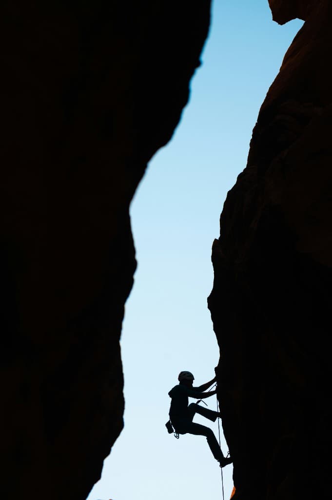Climber ascending between steep rock faces