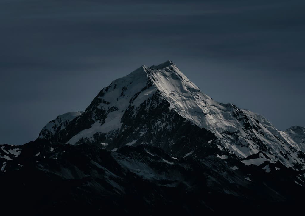 Snow-covered mountain peak against a dark sky